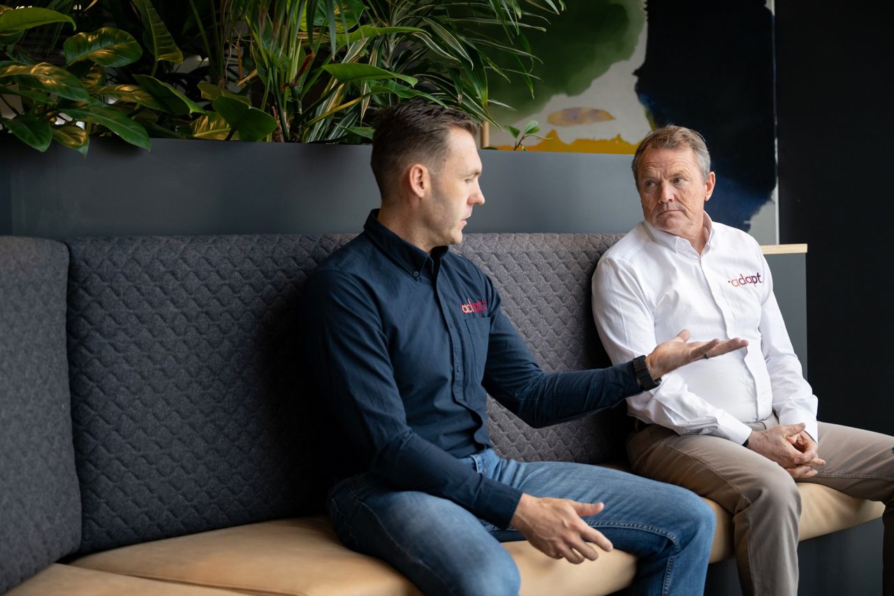 An Adapt coach working through the business with an owner and their leadership team around the boardroom table.