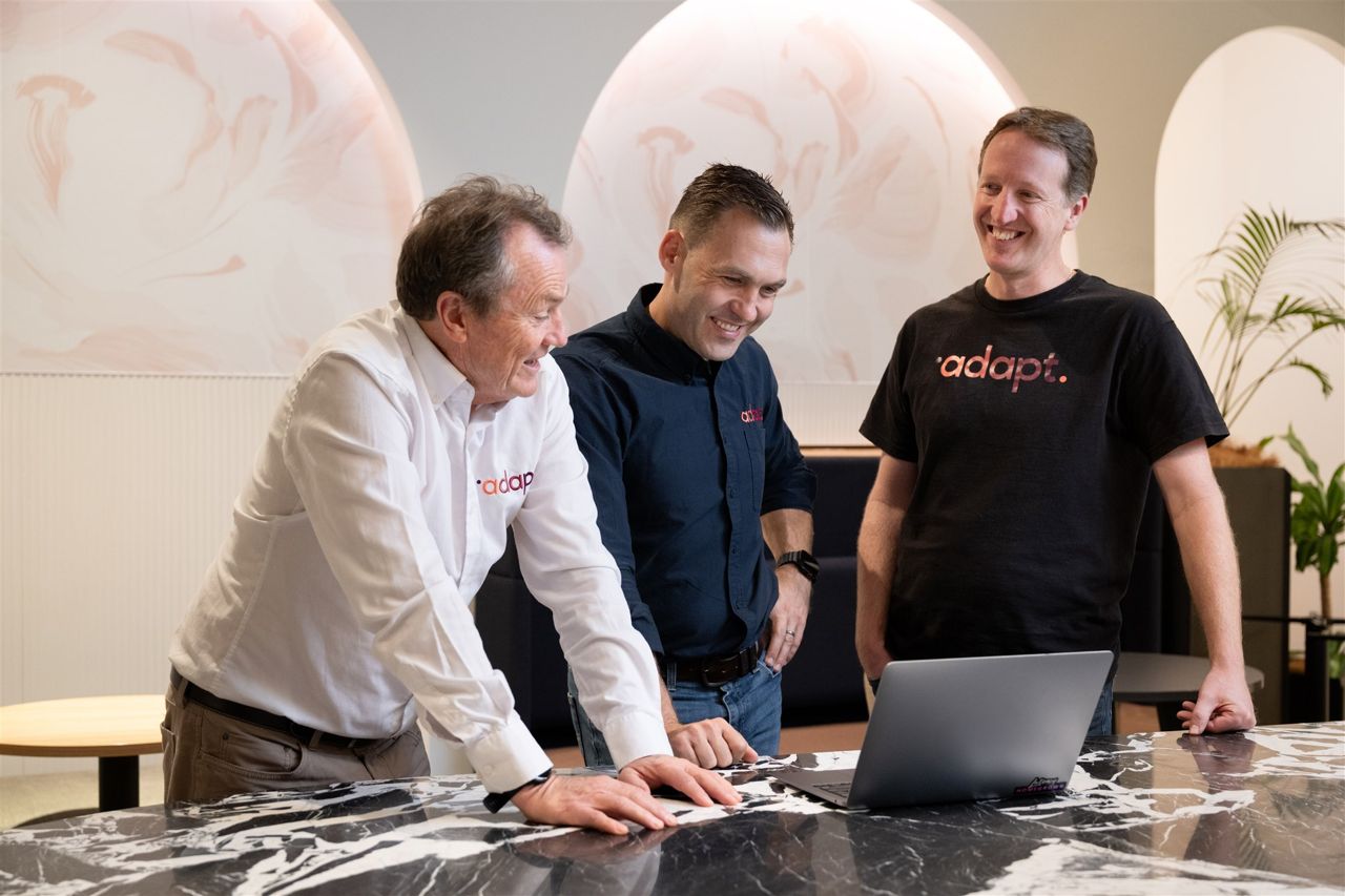 An owner and two of their leaders working together over a laptop, at ease and in step.