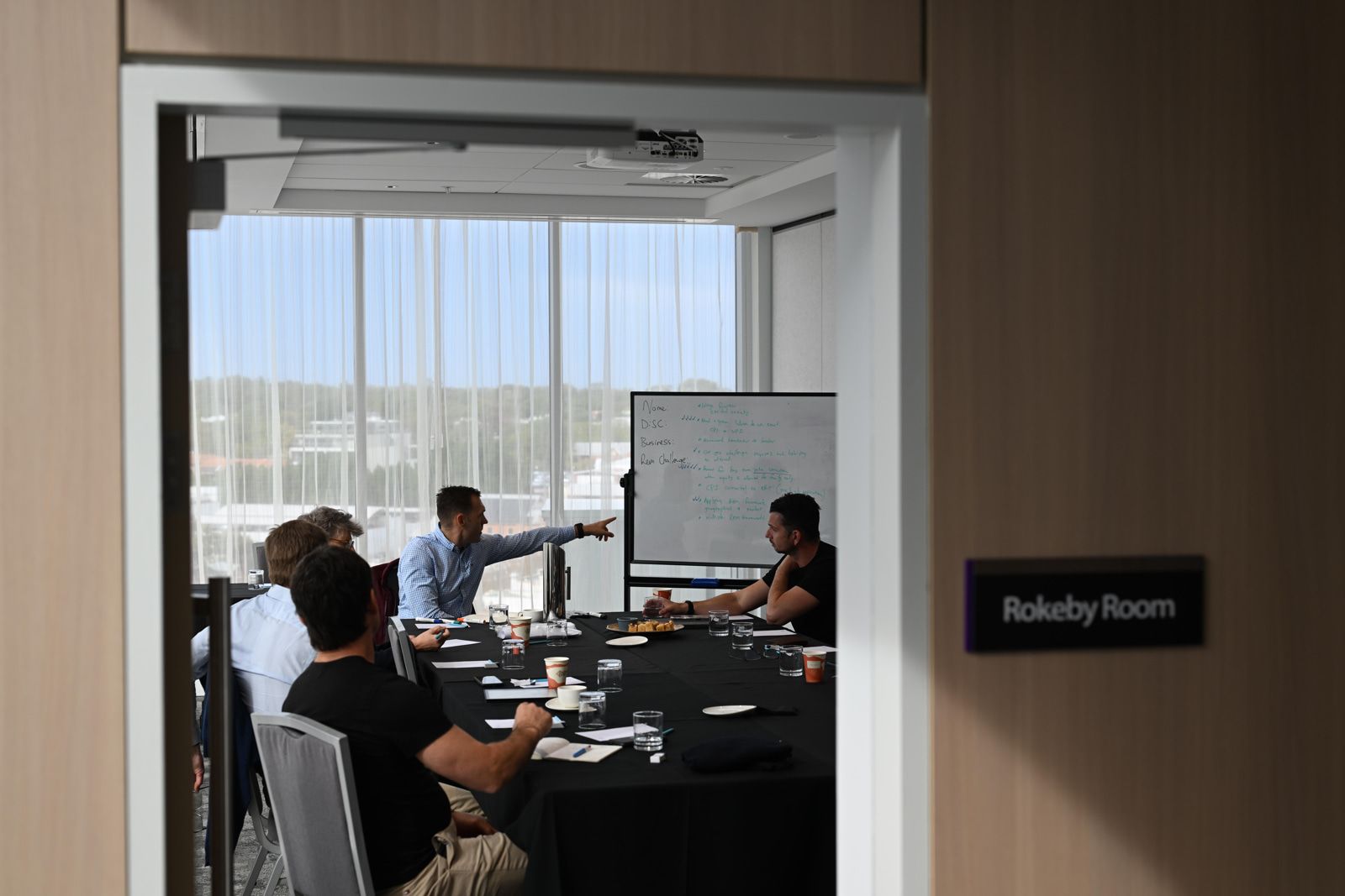 A small group of business owners working around a table in an Adapt session
