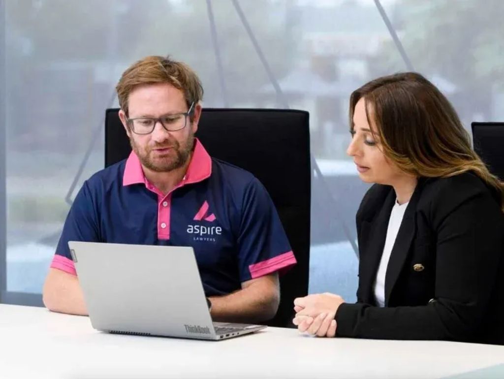 Two Aspire Lawyers team members working together at a laptop