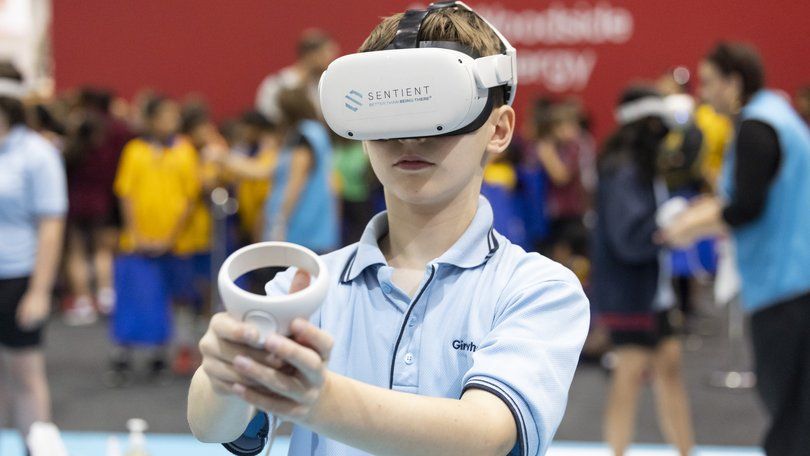 A school student wearing a Sentient-branded VR headset at a careers and STEM expo