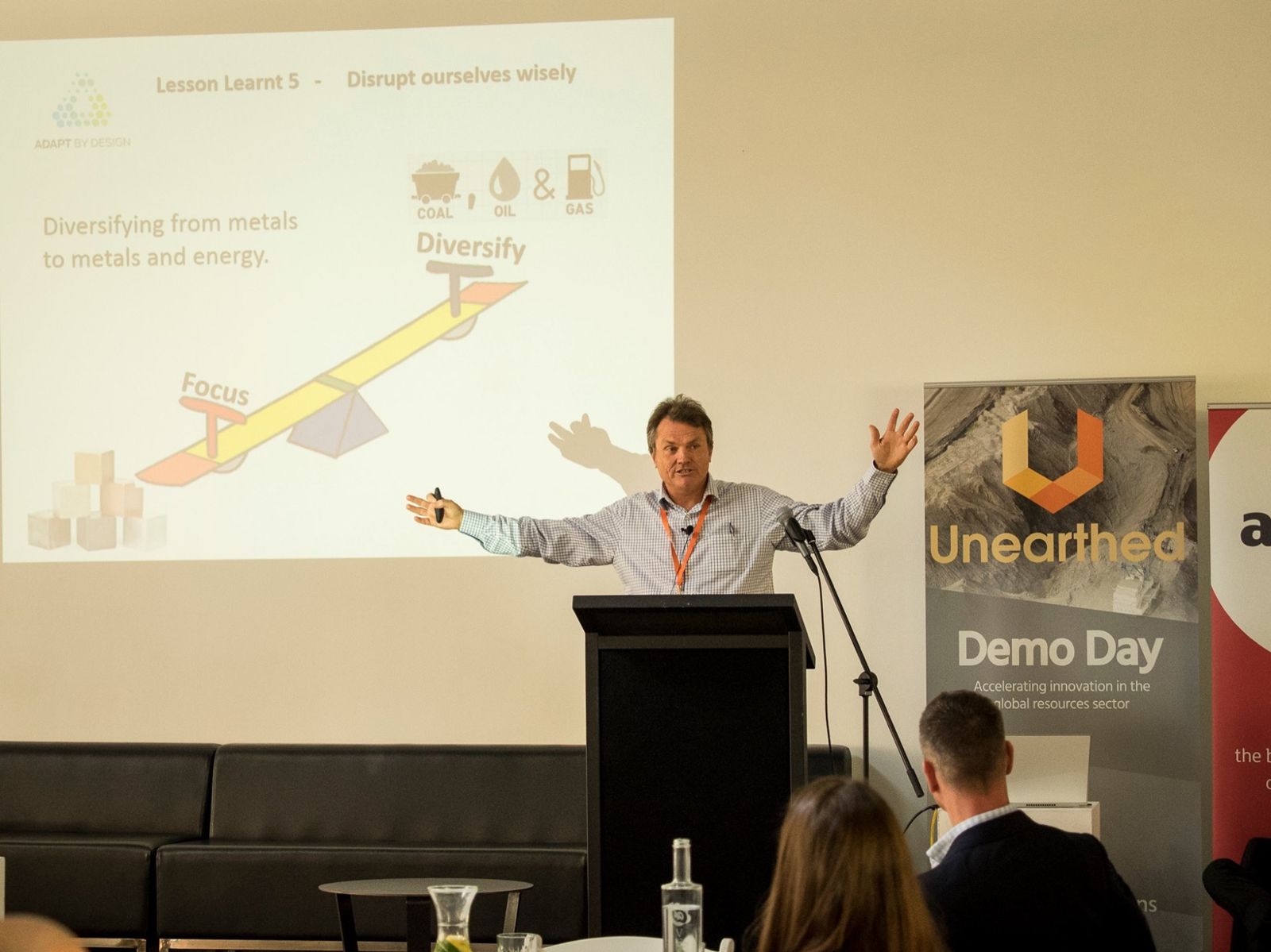 Bill Withers presenting at Unearthed Demo Day, 2015, the Adapt by Design slide behind him.